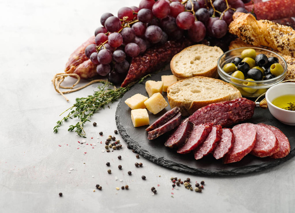 Salami im rustikalen Stil geschnitten. Wurst. verschiedene Wurst mit Käse, Trauben und Oliven. - Foto, Bild