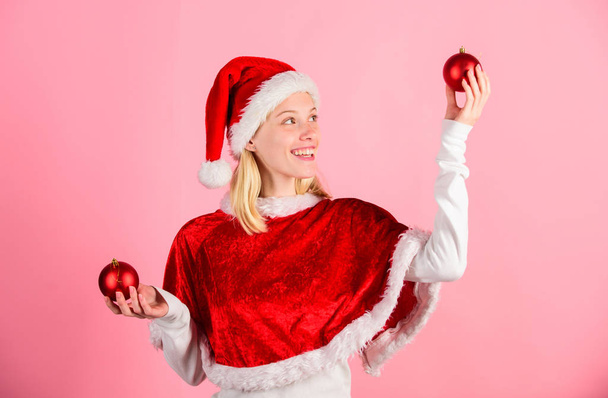 Merry christmas and happy new year. Christmas preparation concept. Lets have fun. Favorite time year christmas. Girl happy wear santa costume celebrate christmas hold ball decor pink background - Foto, imagen