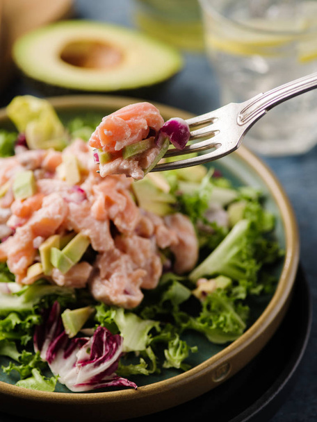 Ceviche is a traditional dish from Peru. Salmon marinated in lemon with fresh lettuce, avocado and onions.  Peruvian food. - Photo, Image