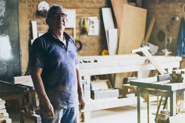 Portrait of senior carpenter in his workshop. - Photo, Image