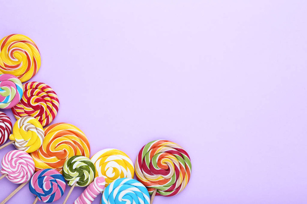 Colorful lollipops on purple background - Foto, imagen