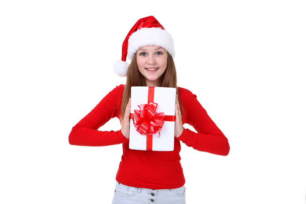 Young girl in santa hat holding gift box on white background - Фото, зображення