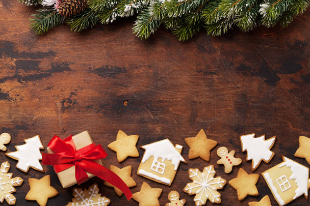 Karácsonyi üdvözlőlap mézeskalács cookie-kat és ajándék doboz fa háttér. Felülnézet helyet az üdvözletet. Lapos feküdt - Fotó, kép