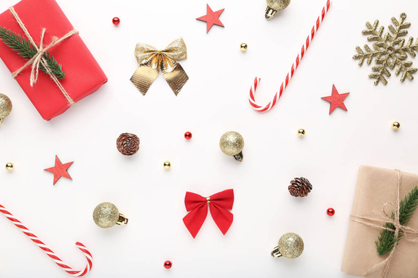 Gift boxes with candy canes and baubles on white background - Fotó, kép