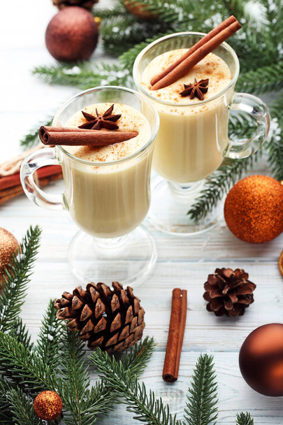 Eggnog in glasses with cinnamon and star anise on wooden table - Zdjęcie, obraz