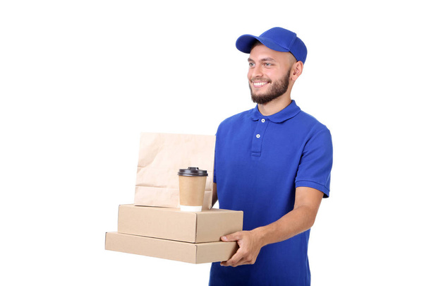 Delivery man with boxes, paper bag and cup on white background - Fotó, kép