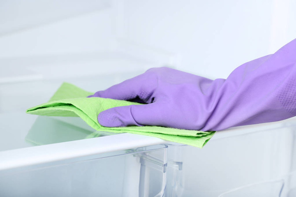 Рука в рукавичці з холодильником для очищення губки
 - Фото, зображення