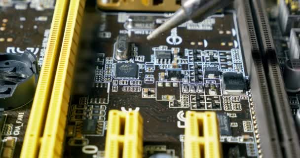 Solderen een printplaat met een soldeerbout. Close-up shot van reparatie op computers en elektronica service - Video
