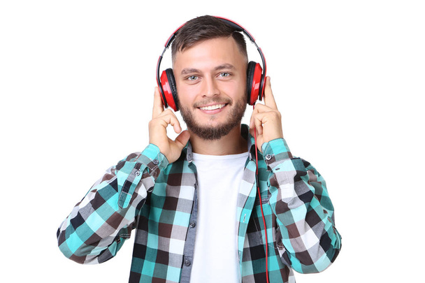 Young man with red headphones on white background - Foto, imagen