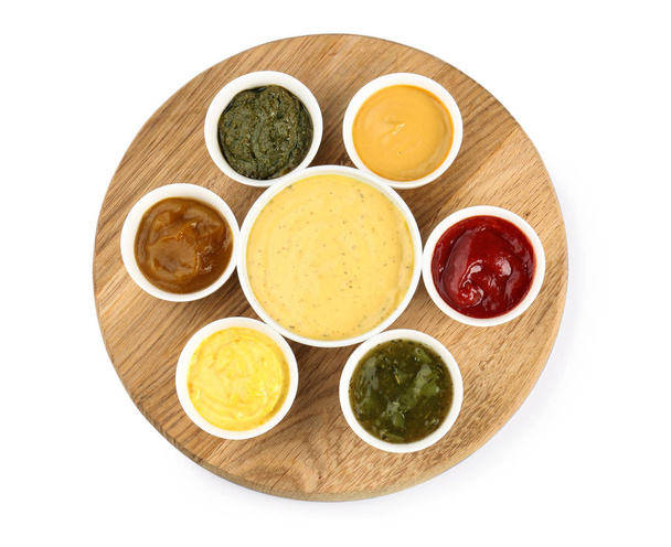 Wooden board with tasty sauces in bowls on white background - Photo, Image