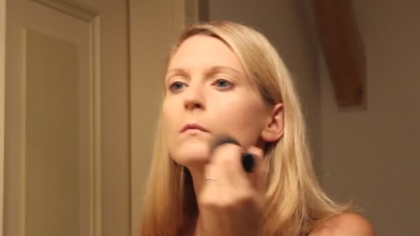 Молода жінка наносить порошок для обличчя пензлем
 - Кадри, відео
