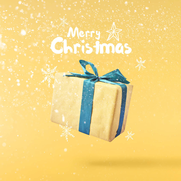 Рождественская идея. Творческая рождественская концепция выполнена путем падения в воздушную подарочную коробку на желтом фоне. Минимальная концепция
 - Фото, изображение