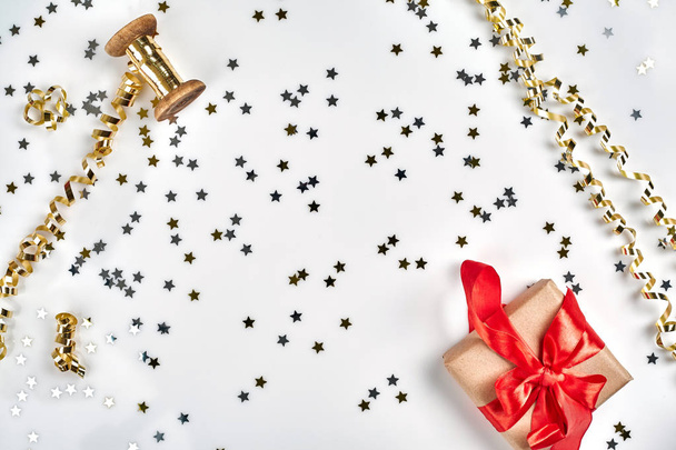 Delicate golvende linten en metalen ster vormige confetti geïsoleerd op een witte achtergrond. Kerst vakantie decoratie concept. Ideale achtergrond voor uw ontwerp. - Foto, afbeelding