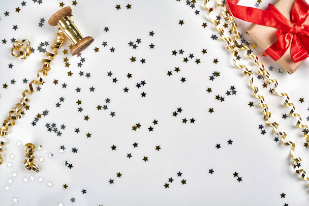 Delikatne faliste wstęgi i metalowe star kształcie konfetti na białym tle. Koncepcja ozdoba wakacje Christmas. - Zdjęcie, obraz