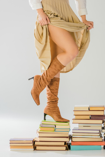 close up of woman in boots walking on vintage books  - Fotoğraf, Görsel