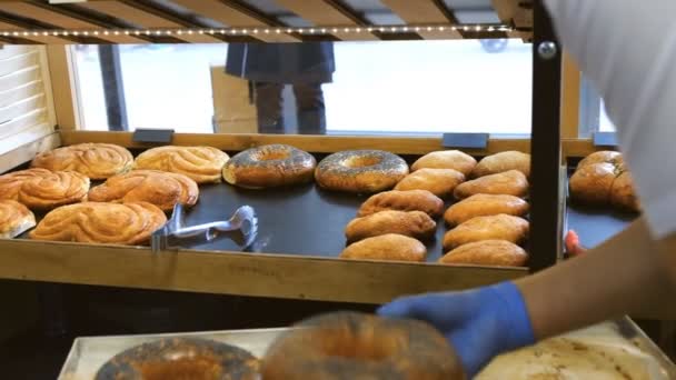 the pastry chef lays out fresh pastries on the storefront in the bakery. - Footage, Video