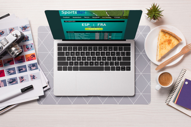 escrivaninha com laptop com site de apostas esportivas na tela, flat lay
 - Foto, Imagem