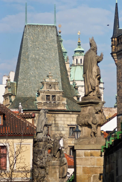 Monument to the Catholic hierarch on the bridge. Tower with a black roof. - Photo, image
