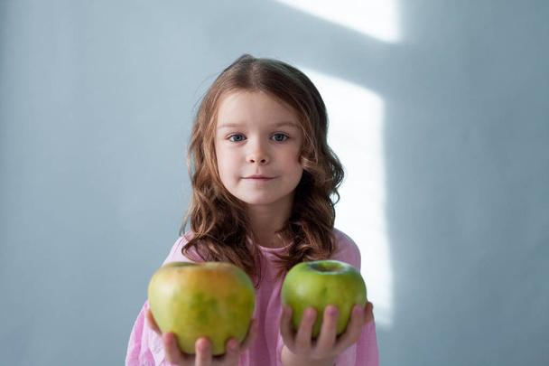 μικρό κορίτσι τρώει πράσινο μήλο τα ωραία δόντια - Φωτογραφία, εικόνα