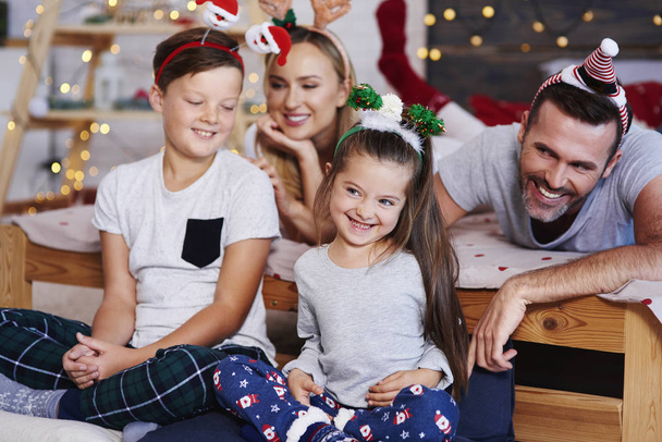 Family celebrating christmas morning together at bedroom  - Photo, Image