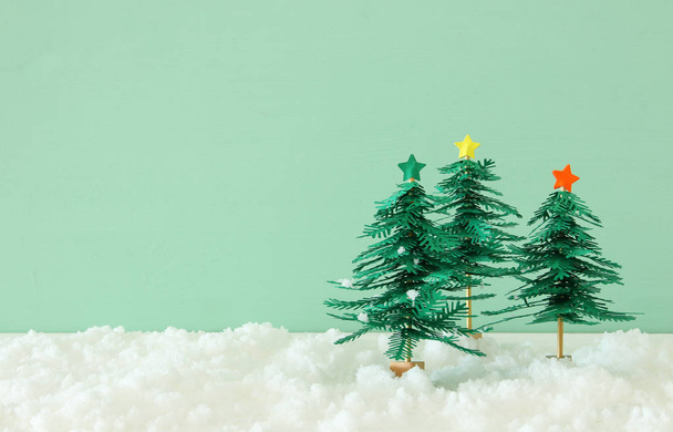 Зображення паперових ялин над білим снігом
 - Фото, зображення