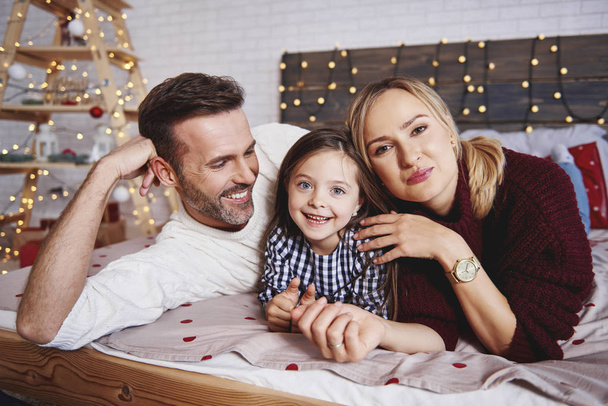 Πορτρέτο του ευτυχισμένη οικογένεια στο κρεβάτι τα Χριστούγεννα - Φωτογραφία, εικόνα