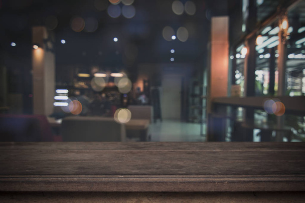 Old wood table in front of blurred cafe restaurant background, copy space can be placed your product. - Photo, Image