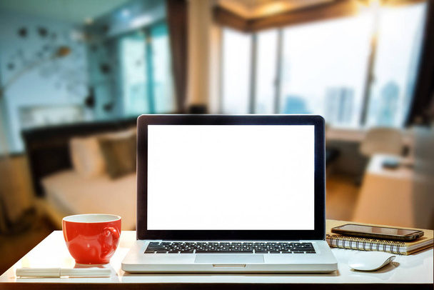 Werkruimte met computer laptop Monitor, toetsenbord, leeg scherm koffie kopje smartphone en tablet op een tabel of wit scherm geïsoleerd in heldere office kamer interieur. - Foto, afbeelding