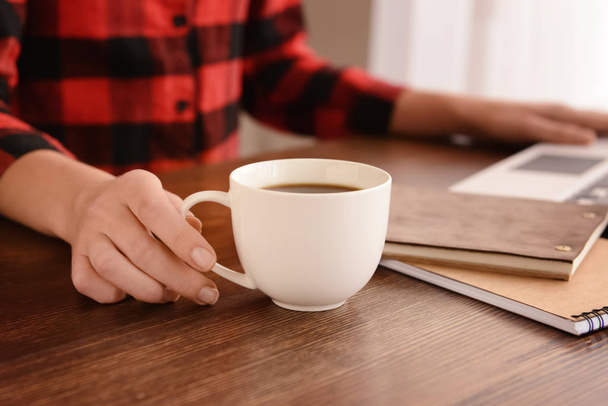Жінка п'є каву за столом
 - Фото, зображення