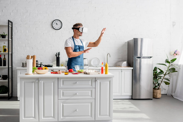 ενηλίκων κουζίνα σε εικονική πραγματικότητα ακουστικά στέκεται στην κουζίνα - Φωτογραφία, εικόνα
