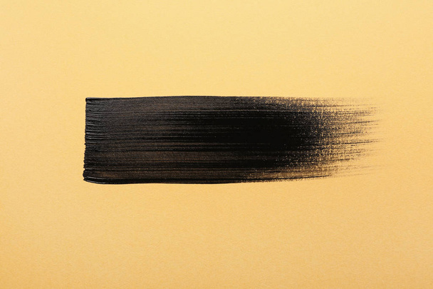 色の背景上の黒いペンキのストローク - 写真・画像