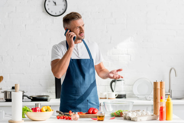  adult man speaking on smartphone at kitchen - Photo, Image