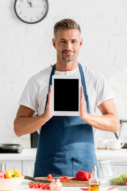adult man holding digital tablet with blank screen at kitchen - Zdjęcie, obraz