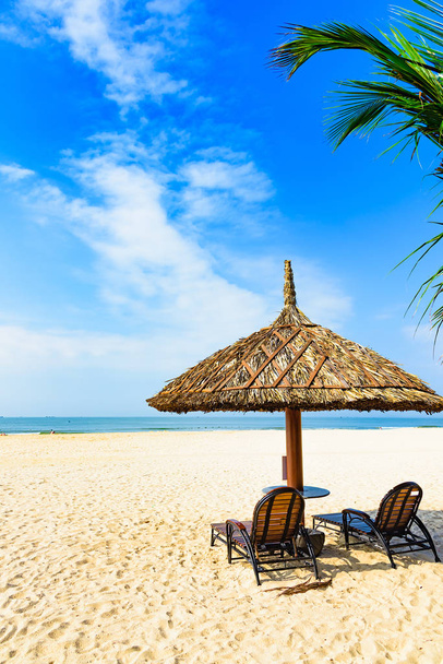 Group deck chairs under an umbrella on a sandy beach sea tropical sunny day - Фото, изображение
