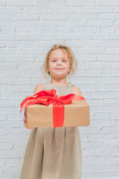 the baby, girl birthday gift, holiday, Christmas, white brick wall background - Valokuva, kuva