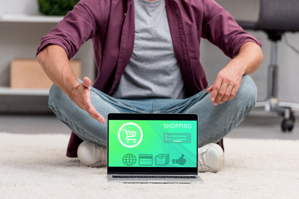 vista recortada del hombre apuntando a la computadora portátil con ilustración de compras en línea
 - Foto, imagen