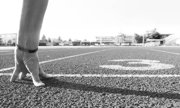 Eine Hand der Frau bereit für den Lauf auf der Leichtathletik-Bahn - Foto, Bild