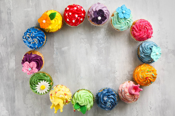 Quadro feito de cupcakes saborosos no fundo cinza
 - Foto, Imagem