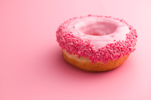 Sweet glazed donut on pink background. - Foto, imagen