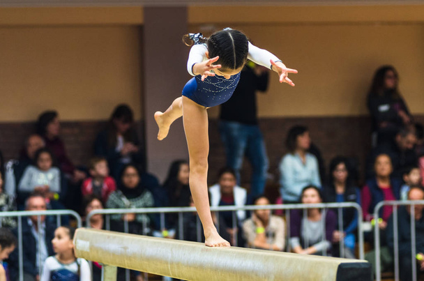 Joven gimnasta femenina realizando handstand en la viga de equilibrio
 - Foto, Imagen