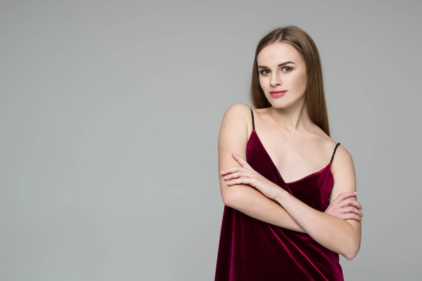 Портрет позування молодої моделі довгошерстої блондинки в темно-червоній сукні, що показує емоції
 - Фото, зображення