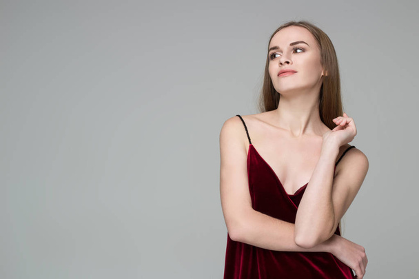 Pózol a fiatal modell hosszú hajú szőke lány mutatja érzelmek sötét piros ruhás portréja - Fotó, kép