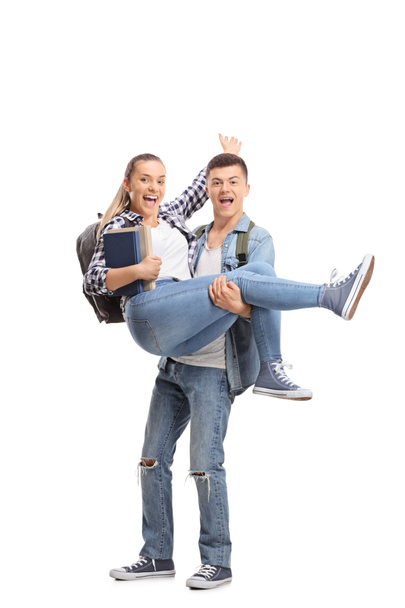 Full length portrait of a teenage boy carrying a girl in his hands isolated on white background - Foto, Imagem