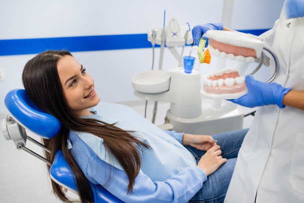 Стоматолог вчить милу дівчину про гігієну порожнини рота
 - Фото, зображення