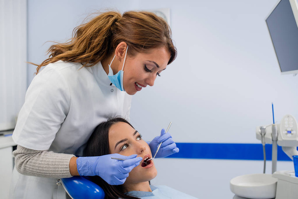 Zahnuntersuchung beim Zahnarzt. Zahnarzt untersucht Zähne von Mädchen - Foto, Bild
