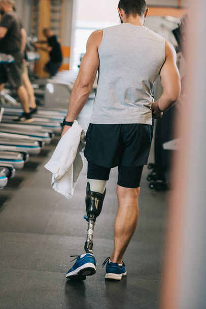 vista trasera del deportista con pierna artificial caminando por el gimnasio
 - Foto, Imagen
