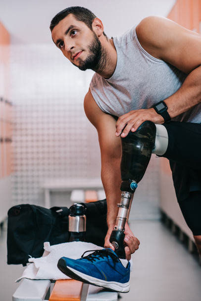 apto jovem desportista com perna artificial se preparando para o treinamento no vestiário ginásio
 - Foto, Imagem
