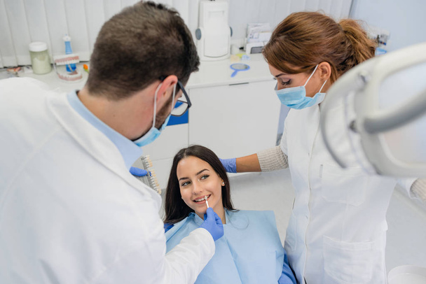 Стоматолог вивчає білизну зубів пацієнта
 - Фото, зображення