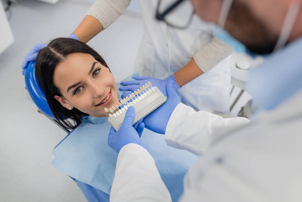 Ο οδοντίατρος εξετάζει λευκότητα των δοντιών του ασθενούς - Φωτογραφία, εικόνα