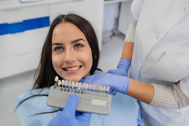歯科医は患者の歯の白さを調べる - 写真・画像